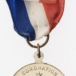 Round medal with kangaroo and emu either side of shield with text around. Red, white and blue ribbon.