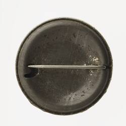 Back of round pin. Metal with horizontal pin.