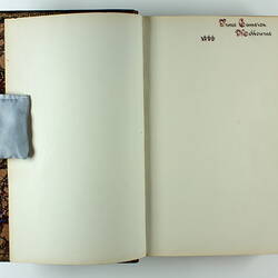Open book with white pages, handwritten annotation at top of right side page. Front pages of book.