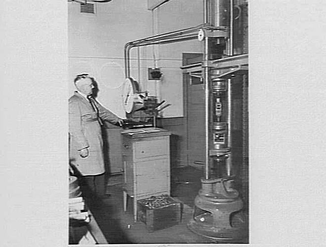 Man operating testing equipment in factory.