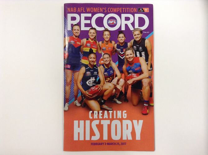 Football record cover with 8 women footballers posing. They were different AFL club jumpers.