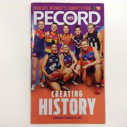 Football record cover with 8 women footballers posing. They were different AFL club jumpers.