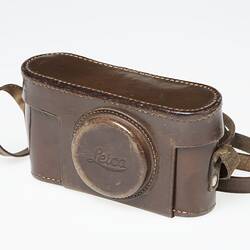 Dark tan leather camera case with shoulder strap.