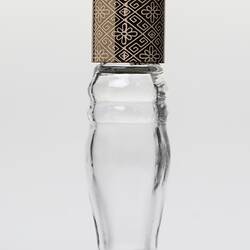 Curved glass perfume bottle, gold plastic lid. Lid has geometric design.
