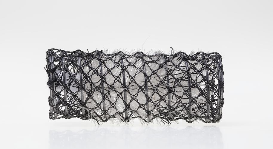 Black cylindrical wire hair roller, plastic whisker inserts.