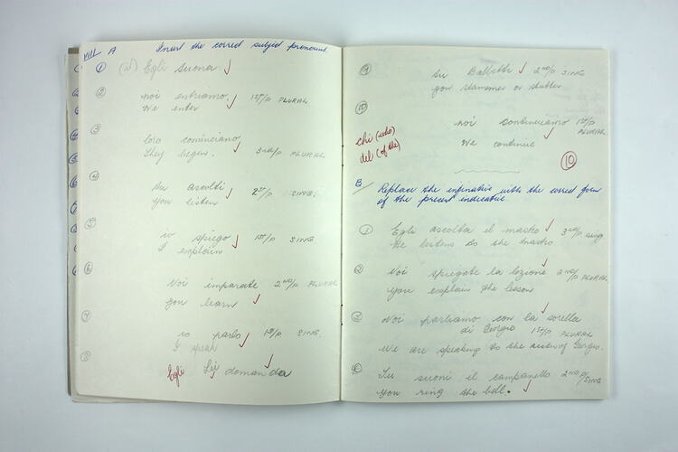 Inside pages of exercise book with hand-writing.