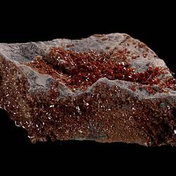 Red-orange crystals on grey rock.