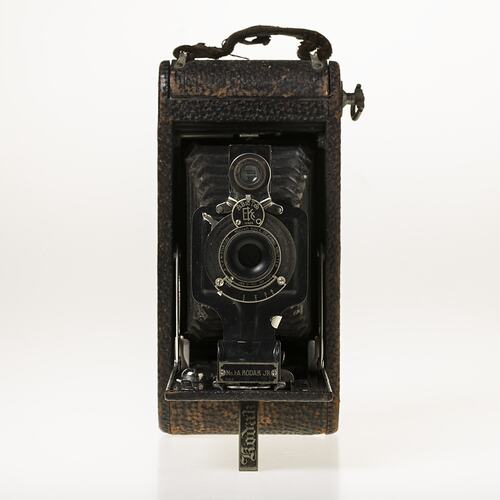 Black camera with leather covering, metal trim. Folds out with bellows.