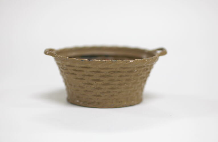 Side view of tiny metal laundry basket.