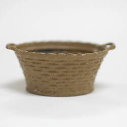 Side view of tiny metal laundry basket.