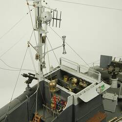 Dark and light grey ship, detail of mast on deck.
