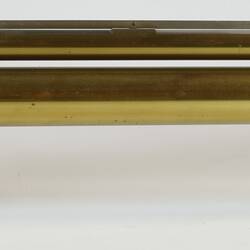 Brass scientific instrument with glass level, side view.