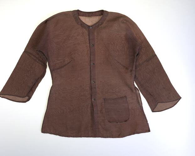 Brown collarless long sleeve button up shirt. Hip pocket at left.