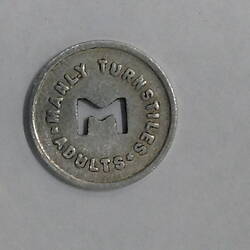Round coin with M cut out of centre.