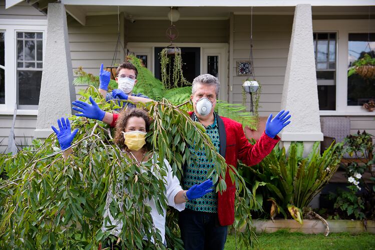 Family posing with surgical masks and gloves outside their home during COVID-19 lockdowns, Northcote, Victoria, 19 April 2020