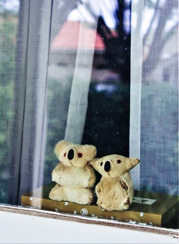 Two teddies placed in window.