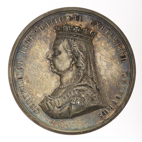 Tarnished silver medal featuring bust of Queen Victoria facing left wearing crown and veil. Text around edge.