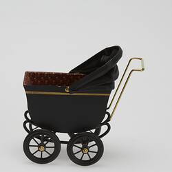Painted black metal miniature pram with gold painted highlights and folding leather hood. Left profile.