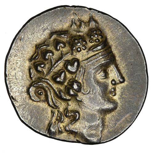 Head of Dionysus facing right wearing ivy wreath.