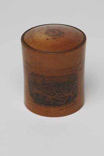 Cylindrical wooden box with lid decorated with a transfer print image of the (Royal) Exhibition Building.
