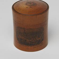 Cylindrical wooden box with lid decorated with a transfer print image of the (Royal) Exhibition Building.