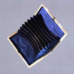 Open case with purple lining and pockets and metal frame