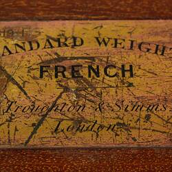 Engraved brass nameplate on top of wooden box.