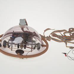 Profile of clear dome containing computer components. Cable attached.