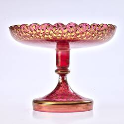 Red glass base/stand of epergne. Shaped like one piece plate on stand. Gilded decoration.