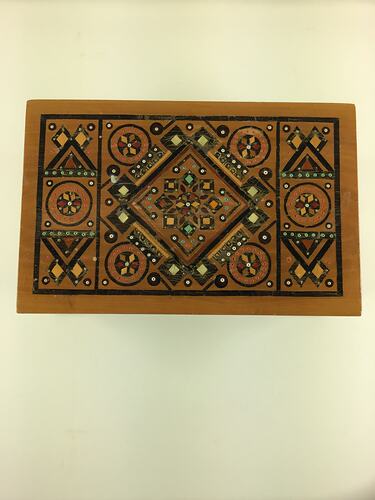 Timber inlay jewellery box. Geometric patterns in dark and light light brown, blue, yellow, white and red.