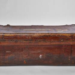 Back of worn brown leather suitcase.