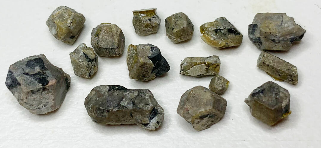 Fifteen small crystals of varying sizes.
