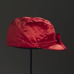 Red silk jockey cap. Black background.