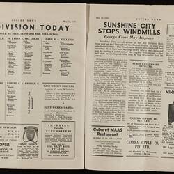 Open magazine with white pages and black printed text and images.