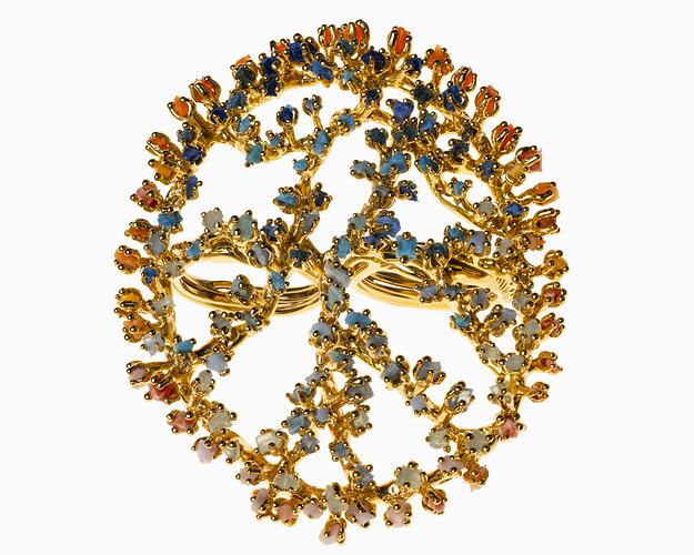Large-scale, openwork design gold oval ring set with multicoloured microplastics.