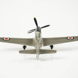 Back of model plane painted silver. Blue, white, red roundel on wings. Front has black four blade propeller. Three wheels.