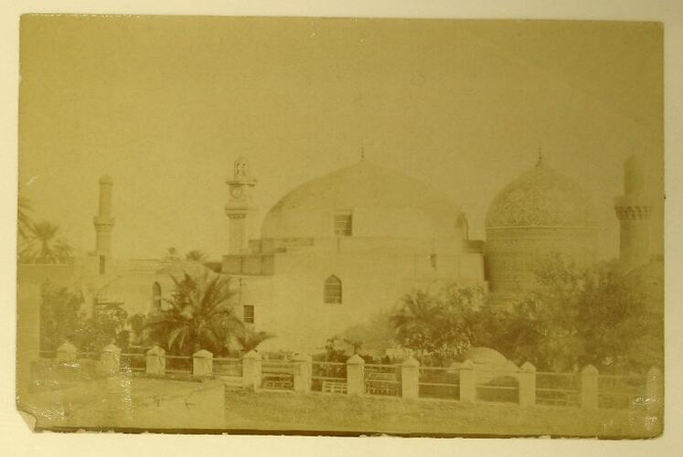 Exterior of Abdul Kadir Jelani Mosque, palm trees in foreground.