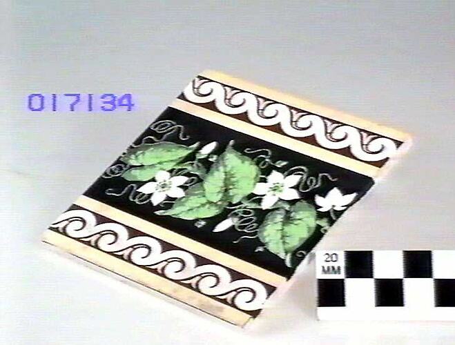 Earthenware tile with plant and scroll pattern