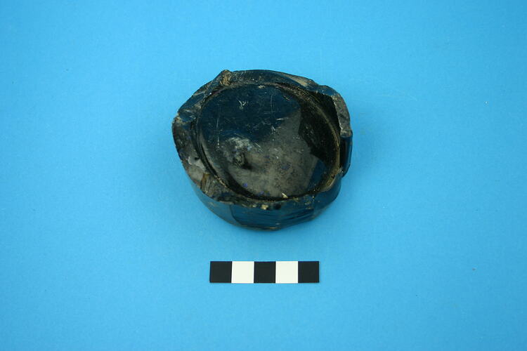 One glass bottle base, dark green.