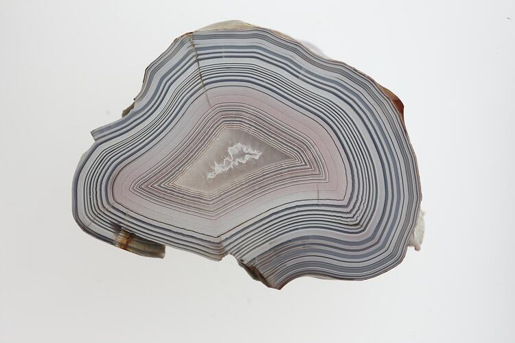 Slice of agate showing grey and pink banding.