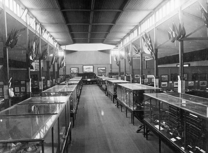 Large hall with flat glass topped display cases along each side.