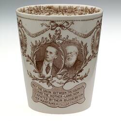 Cream earthenware beaker with sepia floral patterning. Two cameos of men and text below.