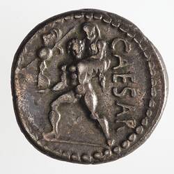 Round coin, aged, figure, carrying second figure on his back, holding small statue in his right hand.