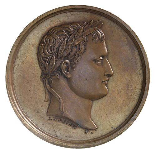 Round medal with profile of male facing right.