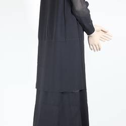Side view of full length black evening dress.