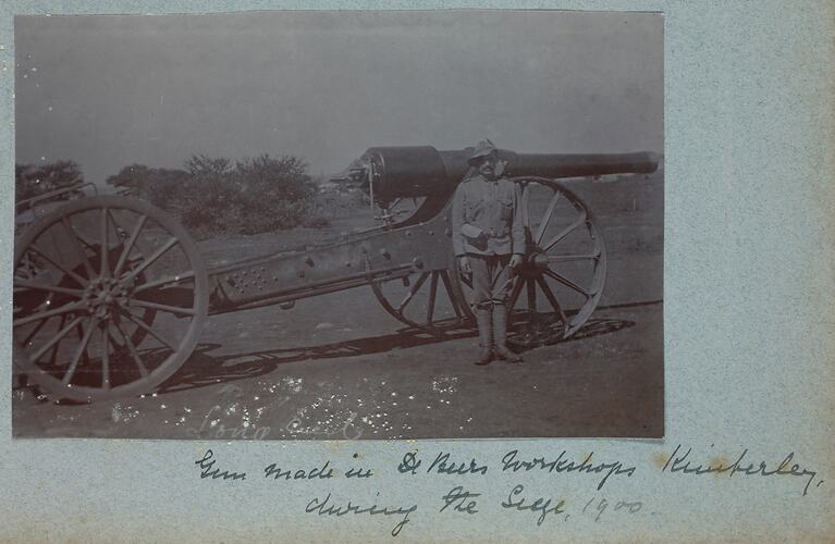 Soldier standing in front of cannon.