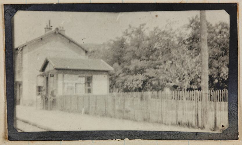 View of a house and picket fence near a railway.