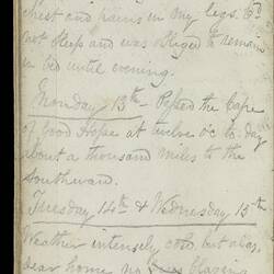 Open diary with handwritten text on discoloured worn page.