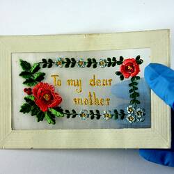 Front of postcard with embroidery showing translucency.