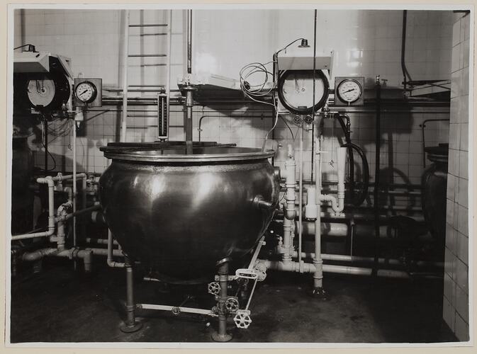 Large vat, connected to pipes and dials.